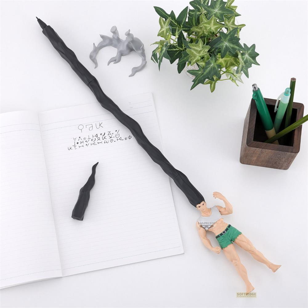 Ein schwarzer Stift mit einer Figur, Notizbuch, Pflanzen und Stiften auf einem weißen Tisch.
