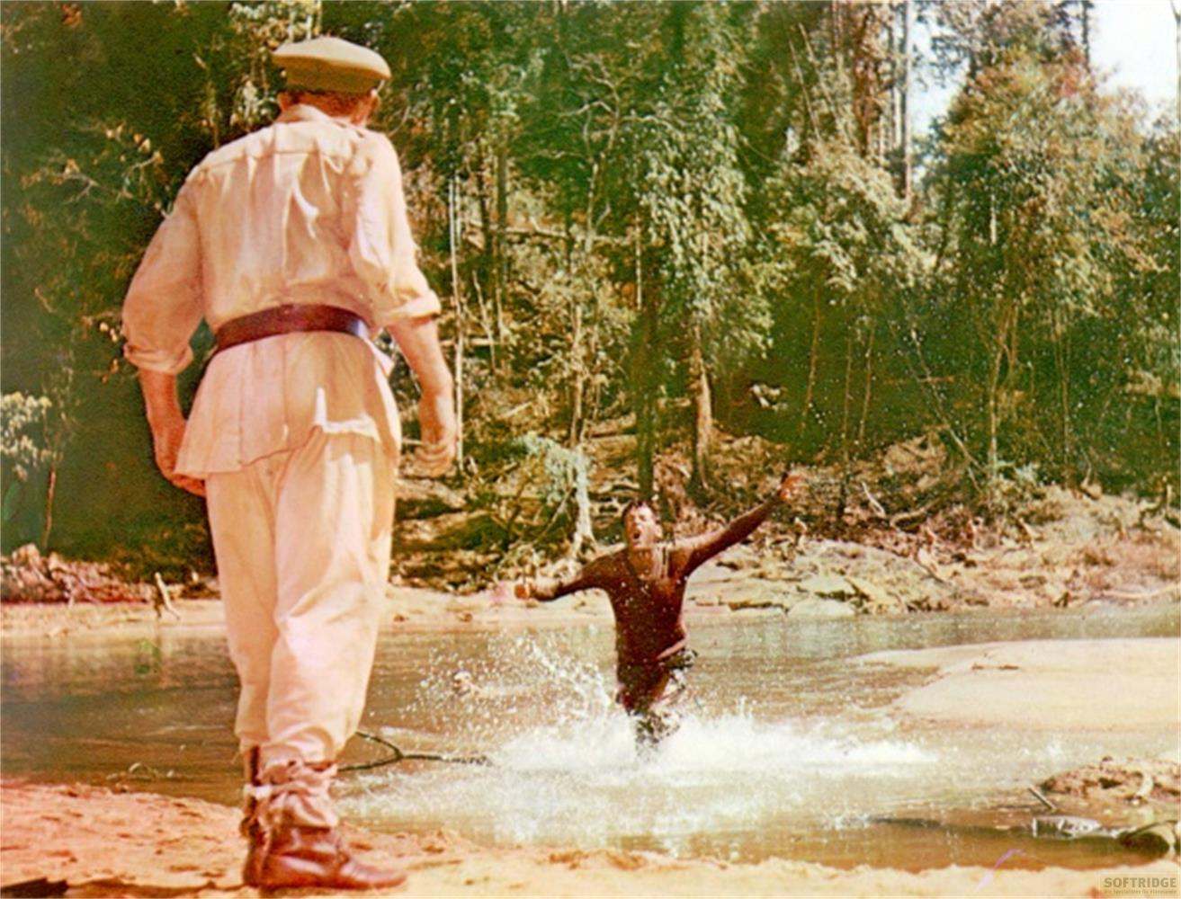 Homme en uniforme sur la rive, homme éclabousse dans l'eau.