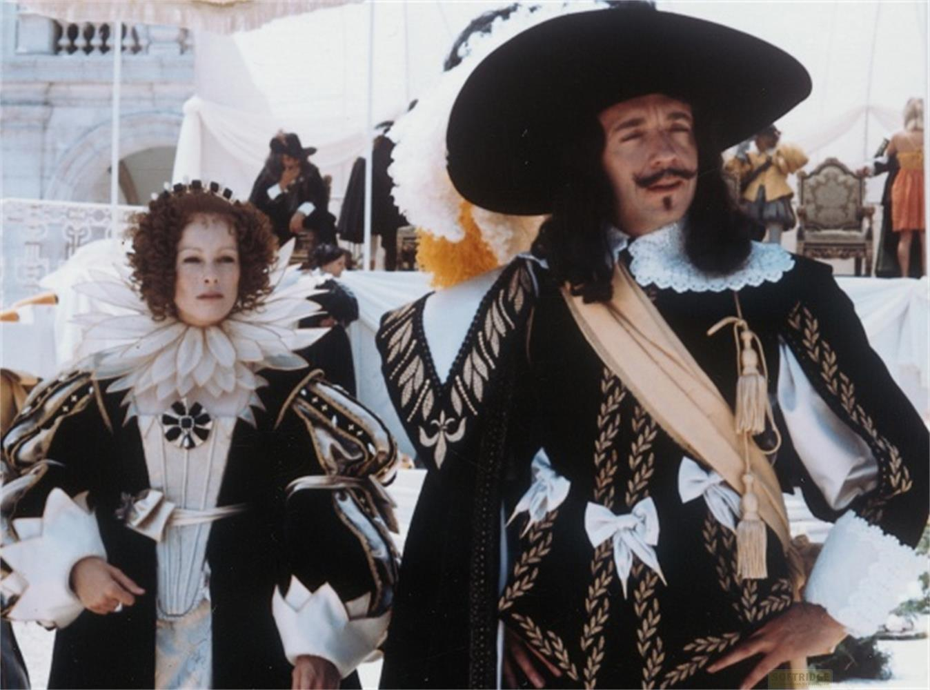 Una donna con anelli e un uomo con cappello e baffi in costumi storici.