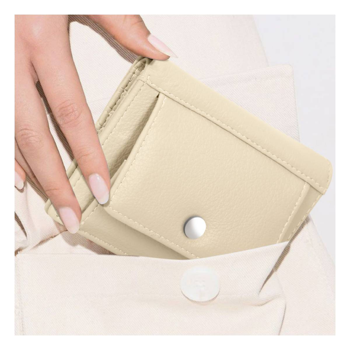 Una mano con uñas claras mete una cartera color crema en un bolsillo.