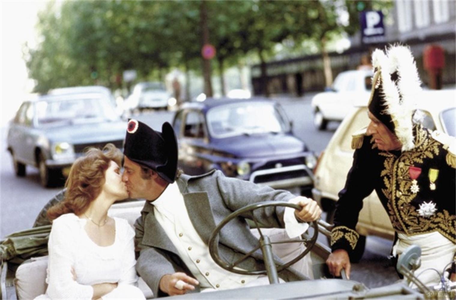 Un uomo in costume napoleonico bacia una donna, con un altro uomo in uniforme vicino.