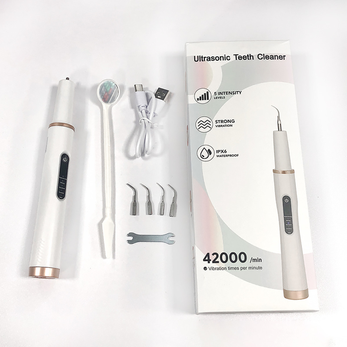 Biała ultradźwiękowa czyścik do zębów z akcesoriami i opakowaniem.