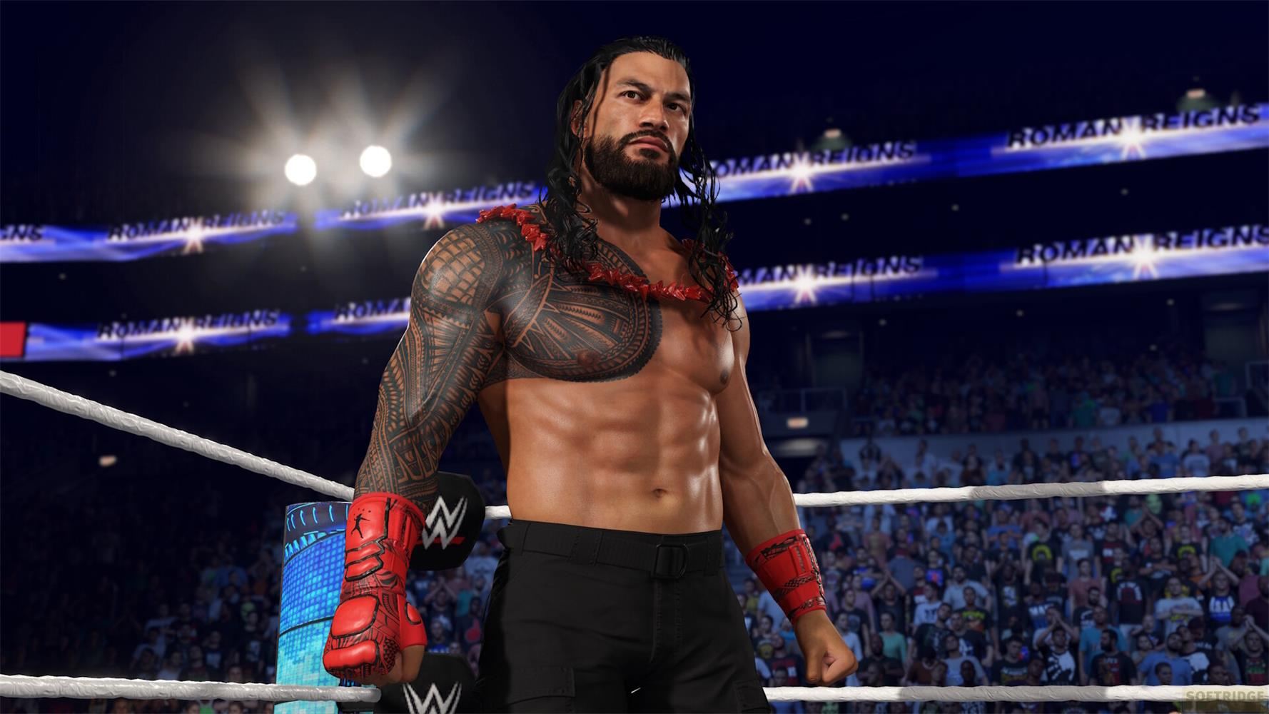 Roman Reigns stoi w ringu, z tatuażami i czerwonym naszyjnikiem.