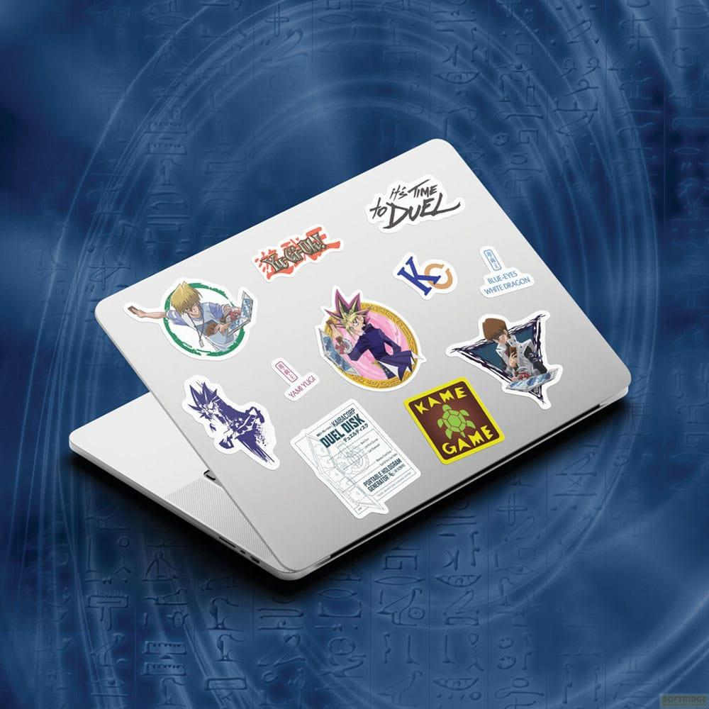 Ein Laptop mit Yu-Gi-Oh-Aufklebern, darunter Charaktere und Symbole.
