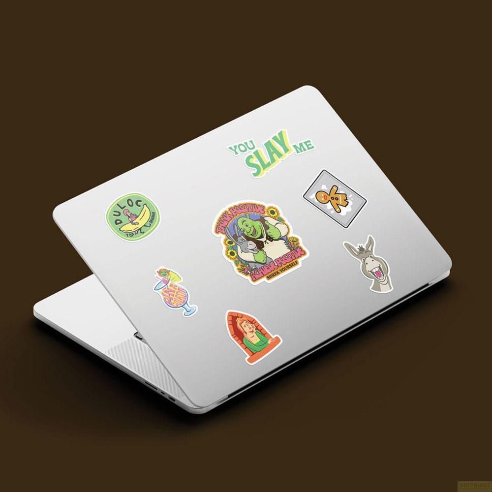 Auf einem Laptop sind verschiedene Aufkleber angebracht: Shrek, Esel, Prinzessin Fiona und mehr.