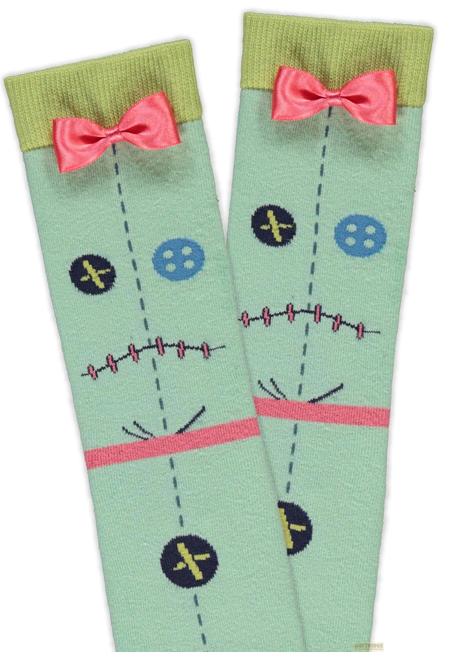 Hellgrüne Socken mit rosa Schleifen und aufgedruckten Gesichtern.