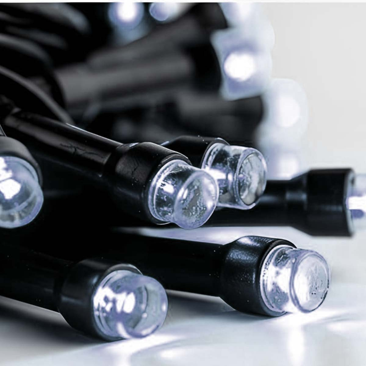 Nahaufnahme von vielen weißen LED-Lichtern mit schwarzen Kabeln.