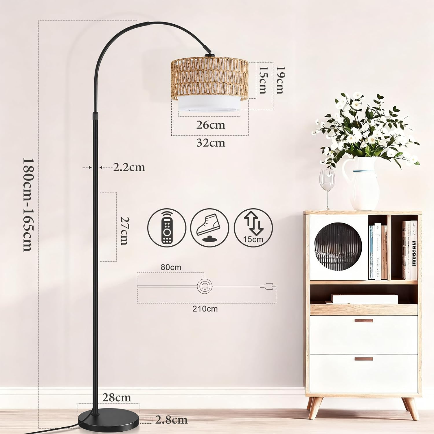 Una lampada da terra ad arco nera con paralume intrecciato è accanto a un mobile bianco.