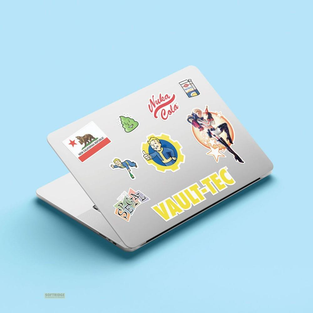 Un portátil adornado con varias pegatinas de Fallout, incluyendo Nuka Cola y Vault-Tec.