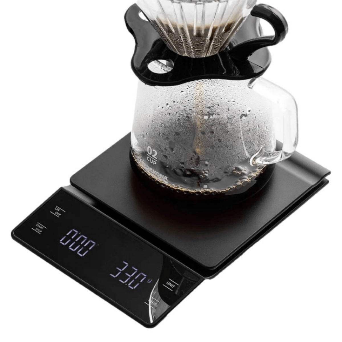 Kaffeemaschine mit Glasbehälter auf einer schwarzen Digitalwaage.