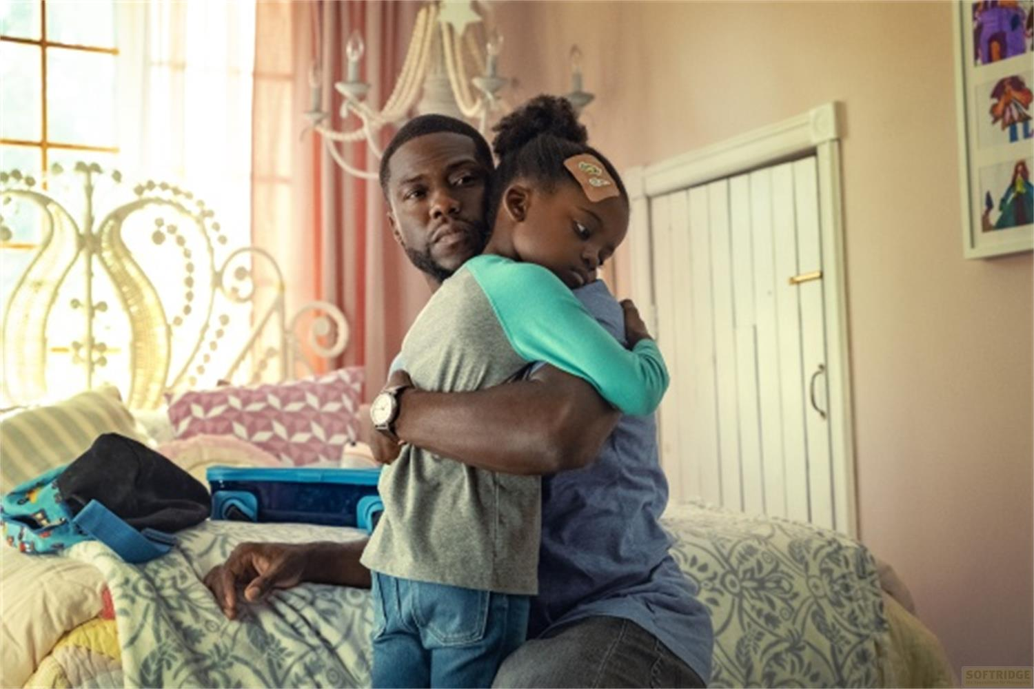 Un uomo abbraccia una bambina con un cerotto sulla fronte.