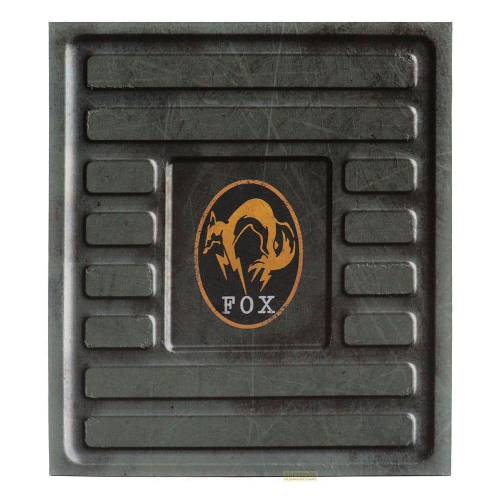 Placa de metal gris con un logo amarillo de zorro y la palabra FOX.