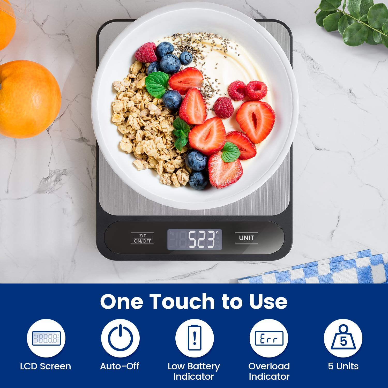 Eine Digitalwaage zeigt 523 g mit einer Schüssel Müsli, Obst und Joghurt an.
