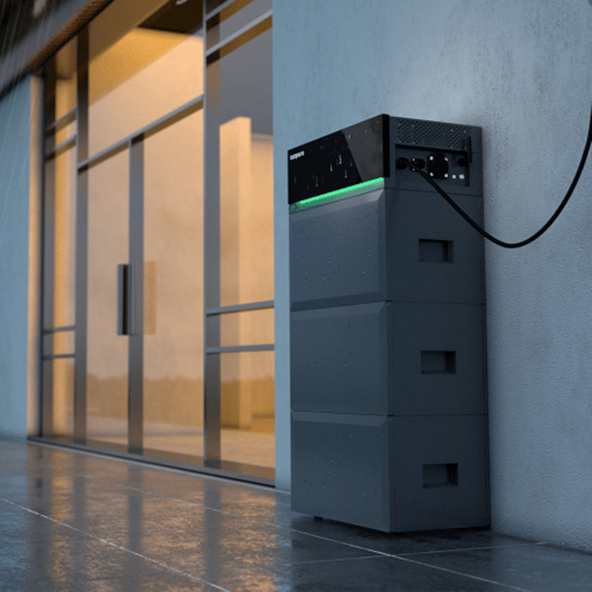 Grauer Batteriespeicher mit grüner Leiste steht im Regen neben Glastür.
