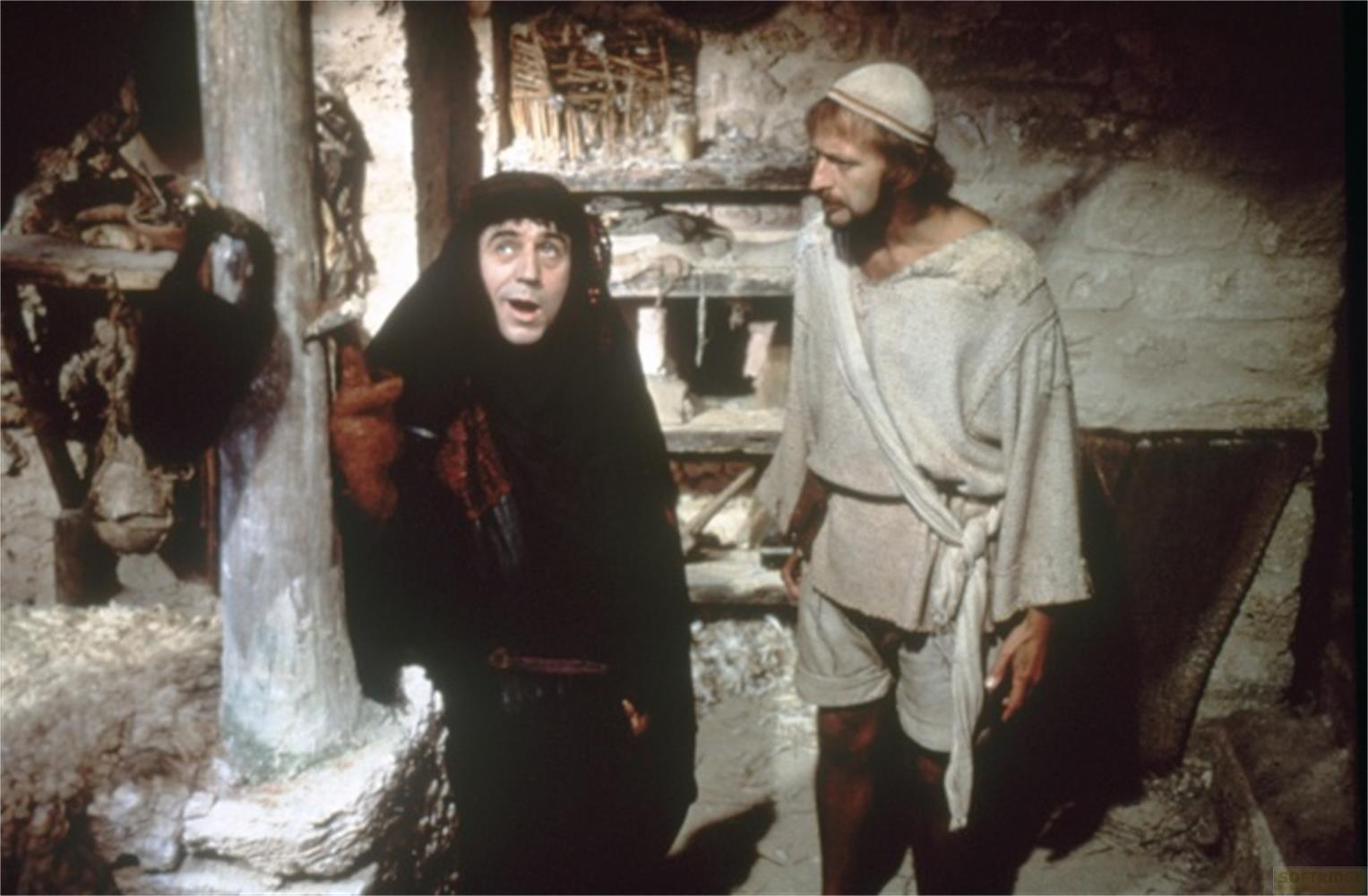 Un homme en robe noire à capuche et un autre en robe blanche avec couvre-chef.