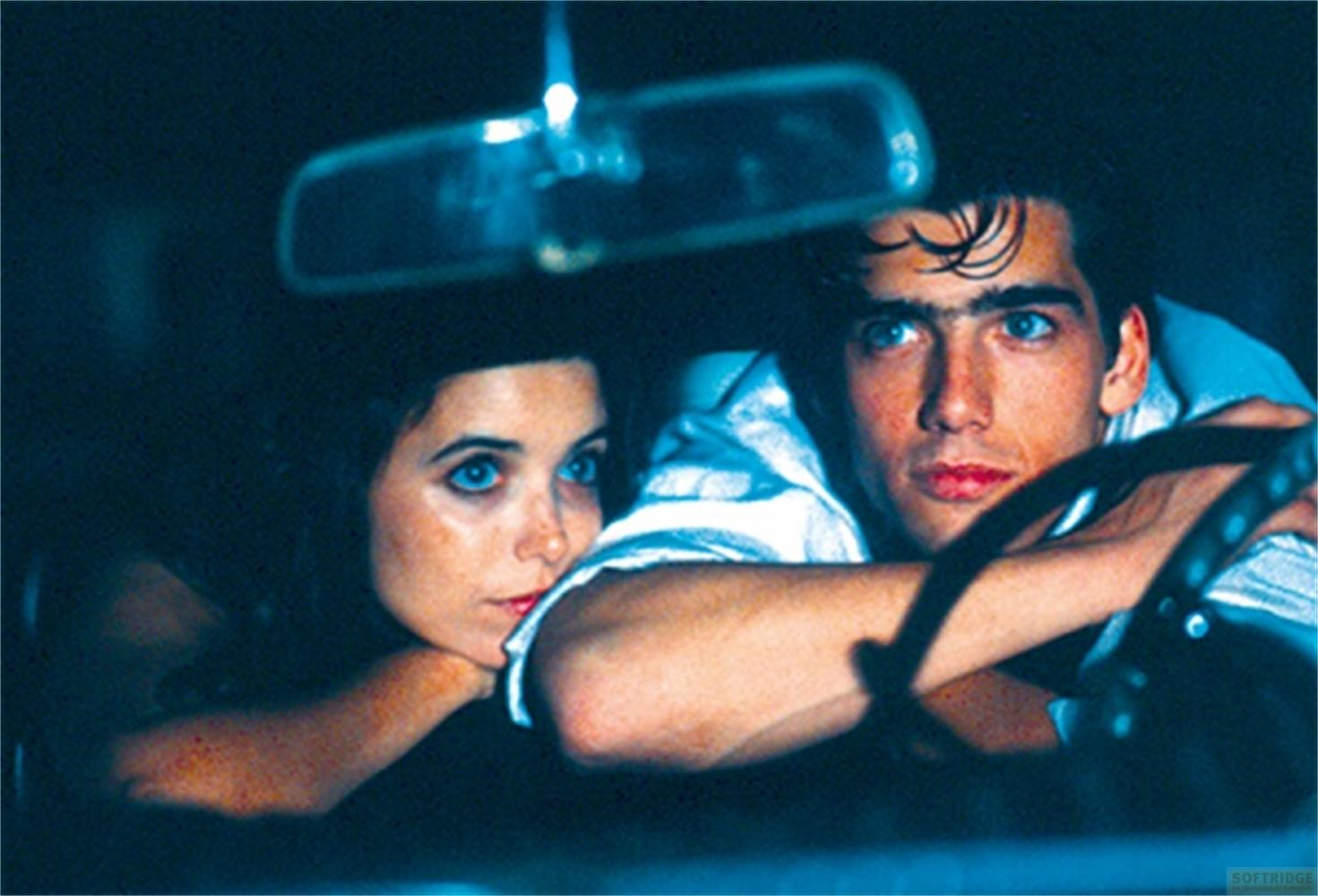 Un homme et une femme dans une voiture, l'homme conduit, la femme s'appuie sur l'accoudoir.