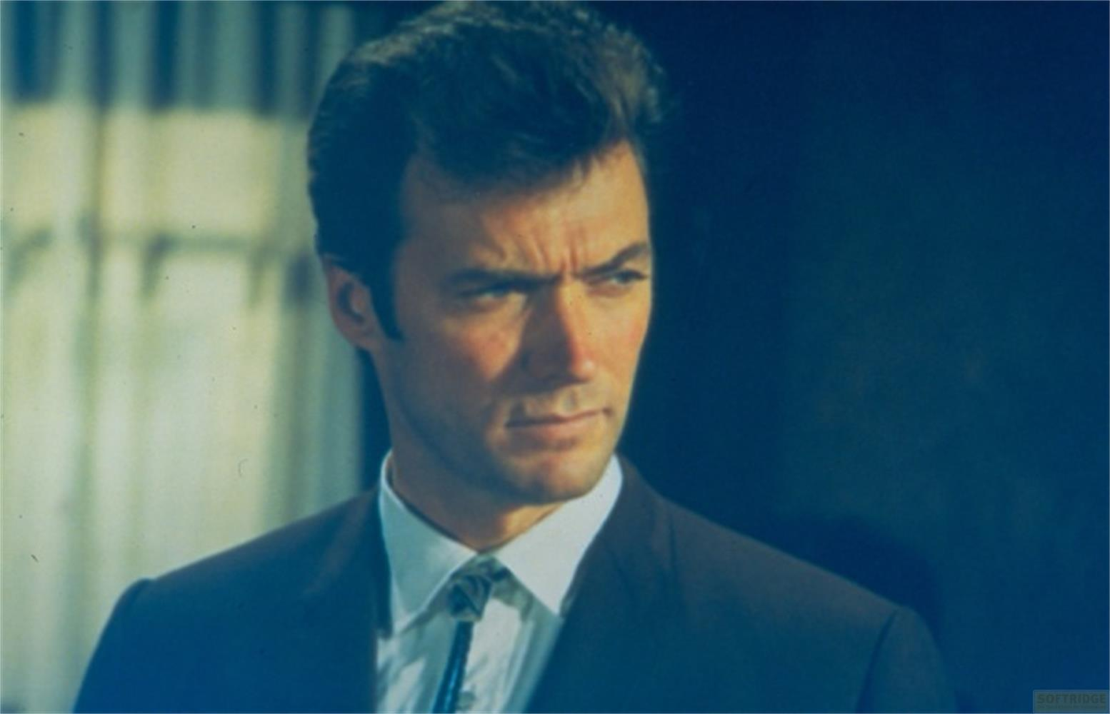 Un homme aux cheveux sombres porte un costume et une chemise.