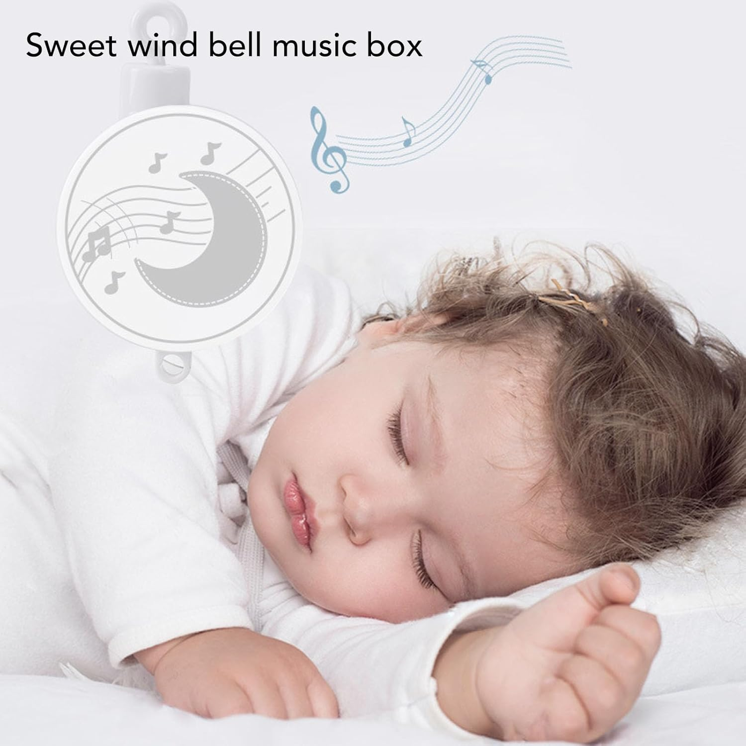 Ein schlafendes Baby mit einem Mobile über ihm, das Musiknoten zeigt.