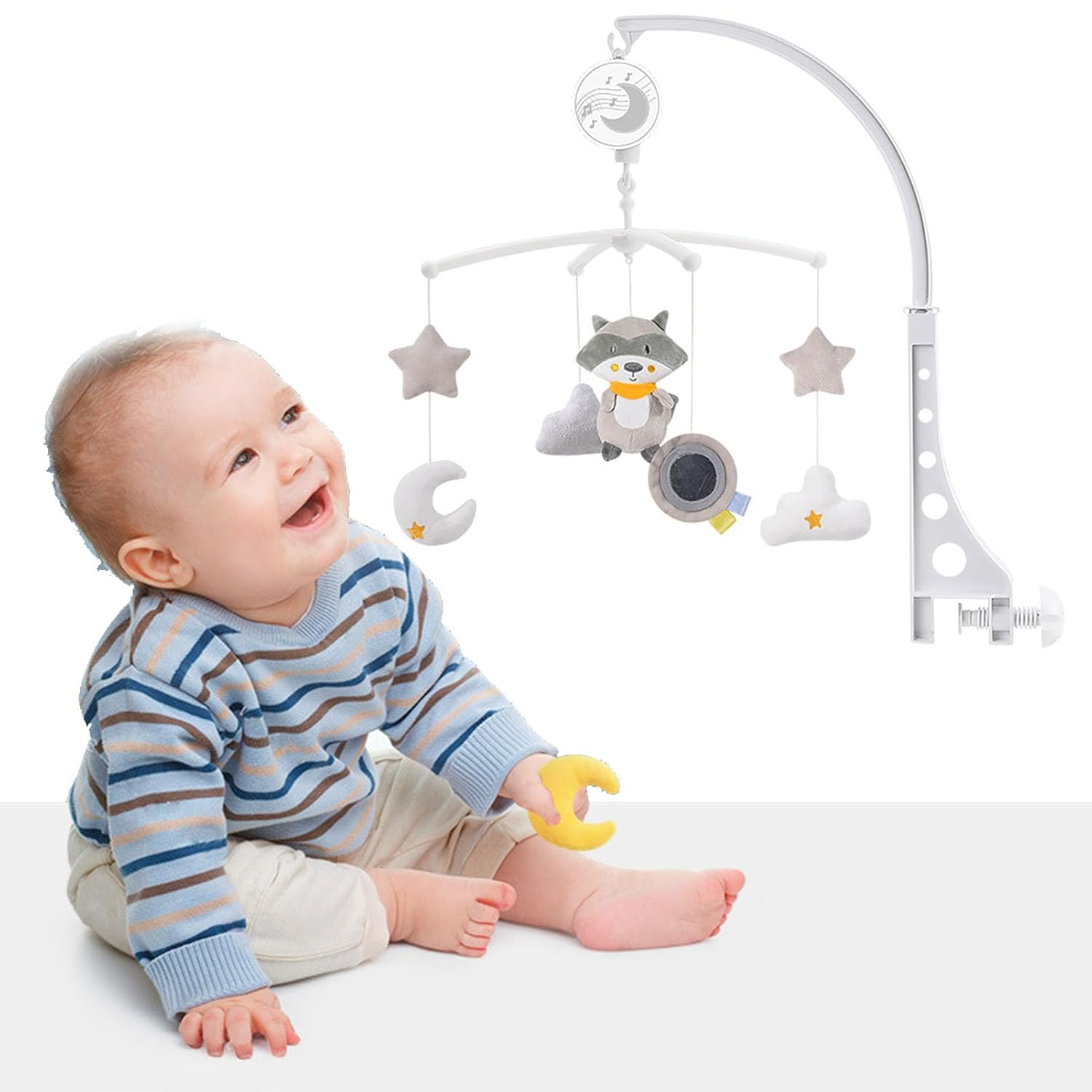 Ein Baby sitzt und spielt mit einem Spielzeug, während eine Baby-Spieluhr über ihm hängt.