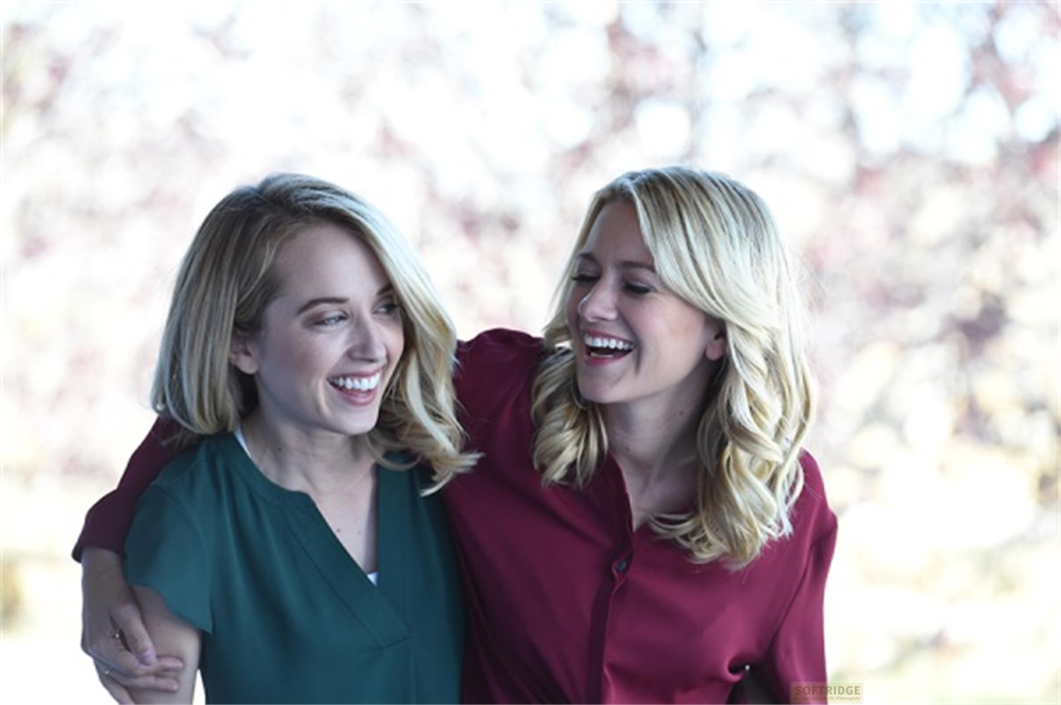 Due donne bionde sorridenti, una in verde, l'altra in bordeaux.