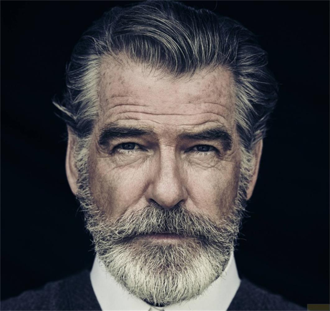 Ritratto di un uomo anziano con capelli e barba grigi, che guarda la telecamera.