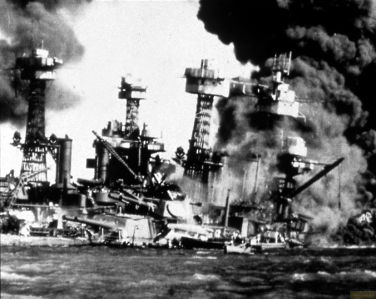 Corazzata in fiamme, fumo denso, sull'acqua.