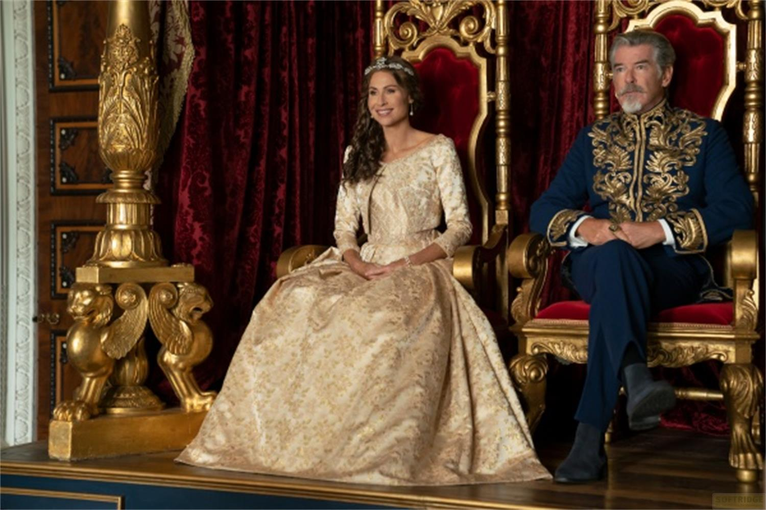 Regina e re siedono su troni dorati davanti a tenda di velluto rosso.