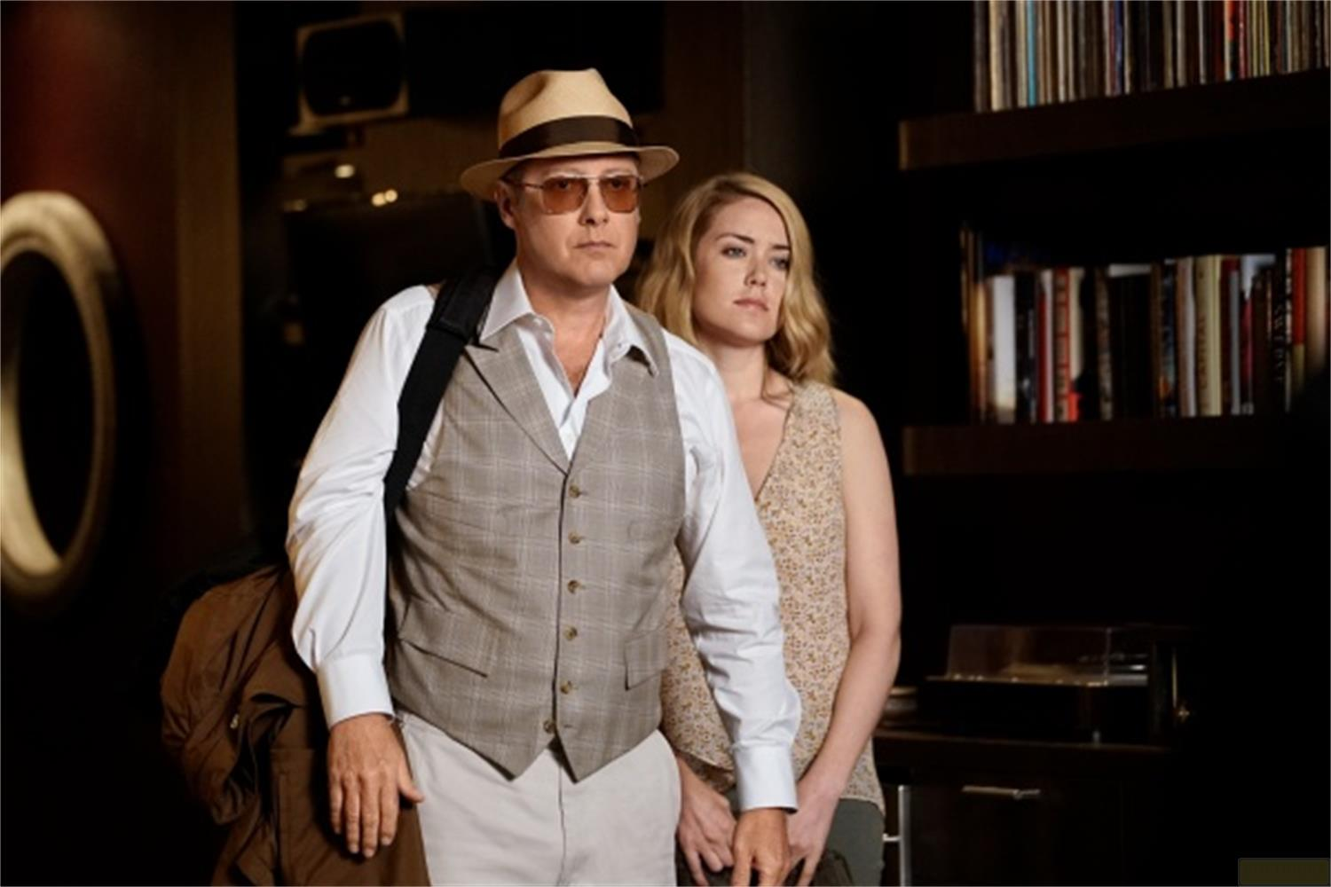 Uomo con cappello e gilet e donna in piedi fianco a fianco.