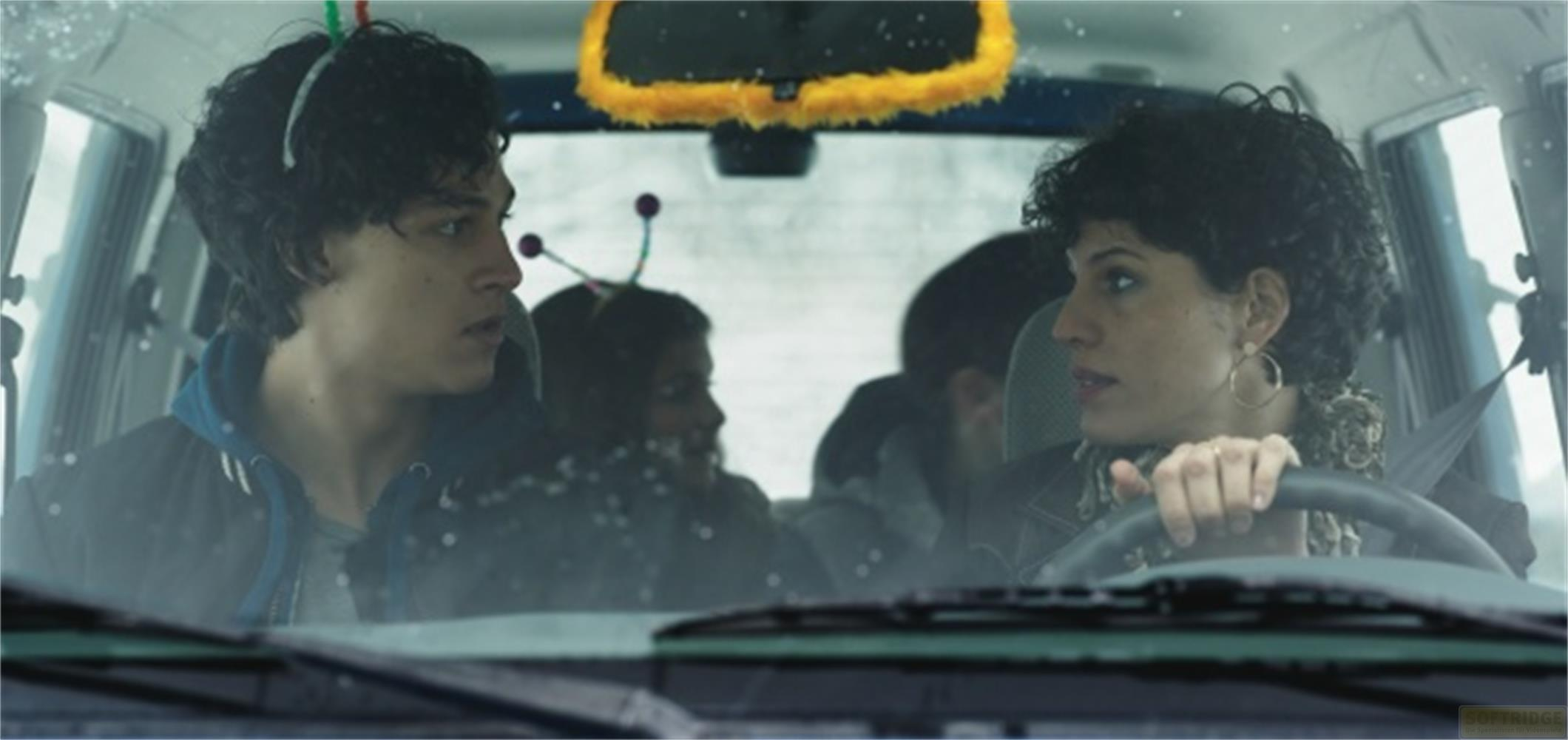 Quattro persone in un'auto, due davanti, due dietro. Nevica fuori.
