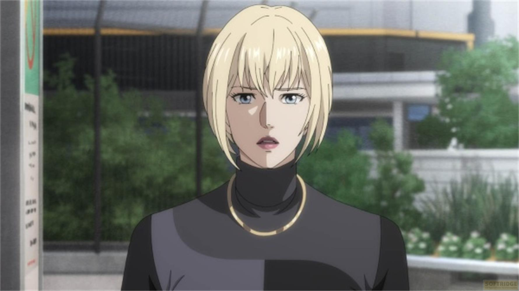 Eine Frau mit blonden Haaren trägt einen schwarzen Rollkragenpullover und eine goldene Halskette.