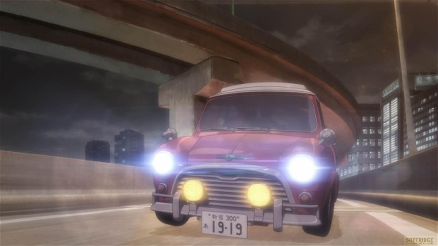 Ein roter Mini fährt nachts auf einer Autobahn unter einer Brücke.