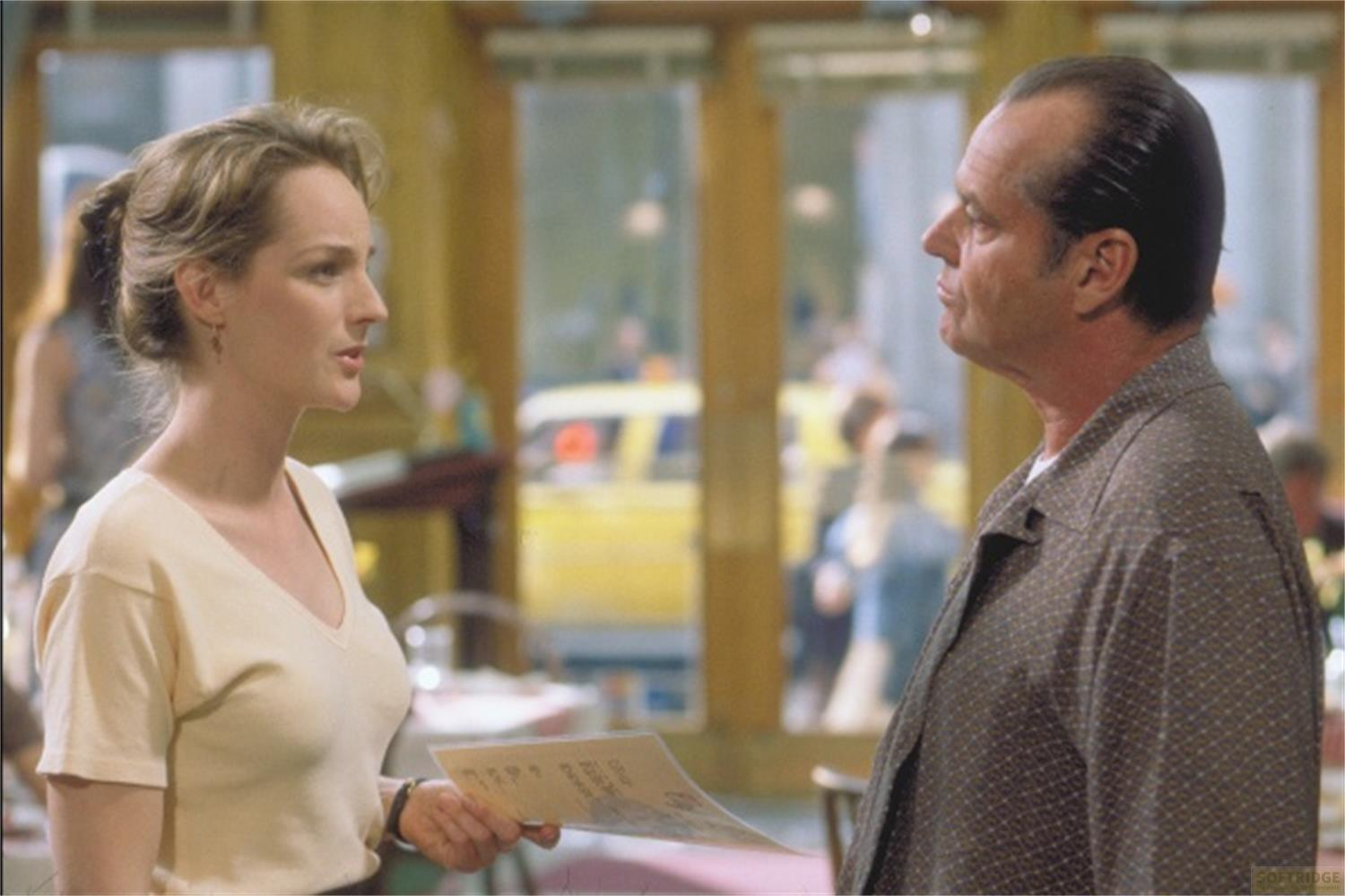 Une femme et un homme parlent dans un restaurant. Des voitures et des gens sont visibles.
