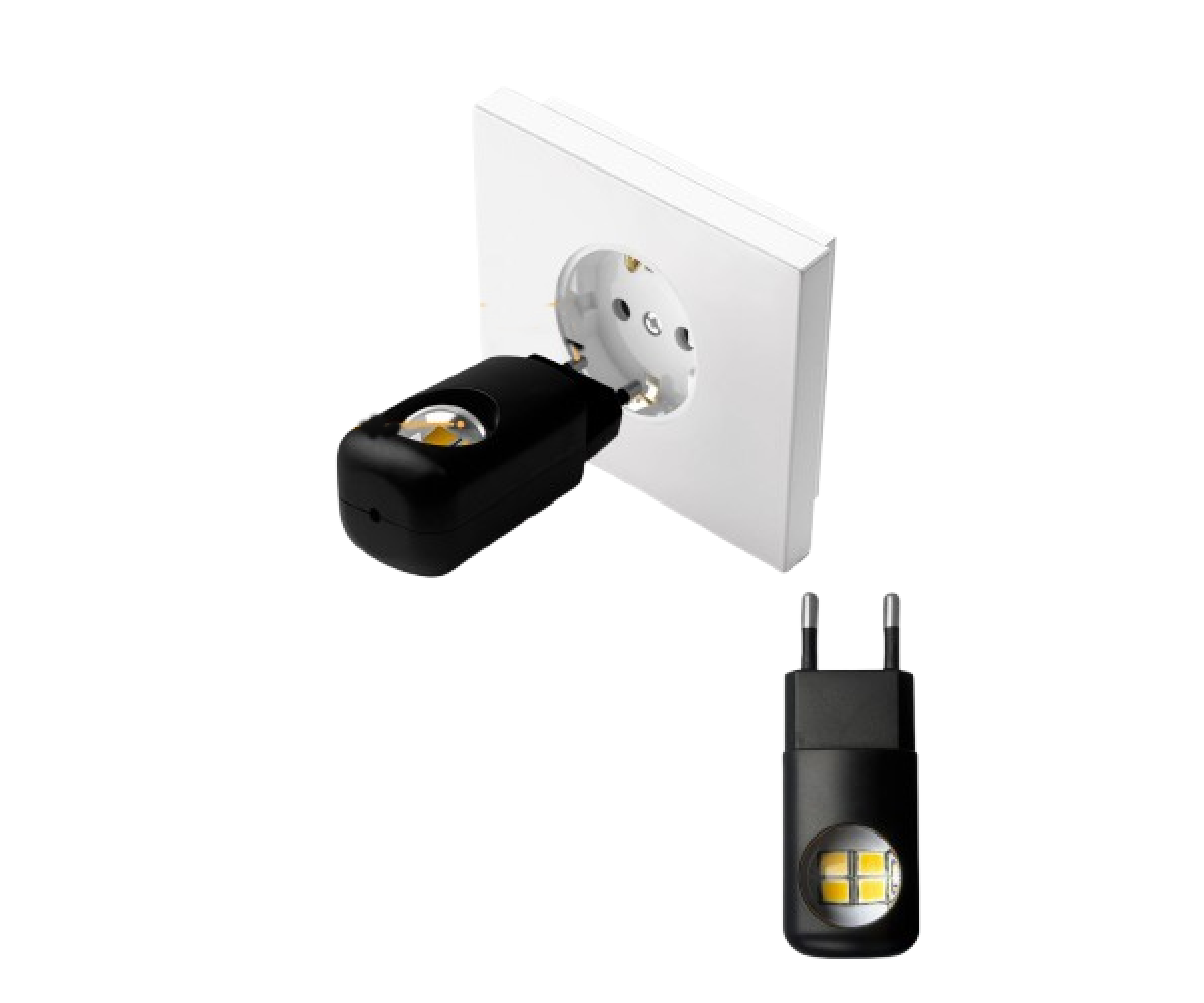 Una spina nera con LED illuminata in una presa a muro bianca. Una seconda spina accanto.