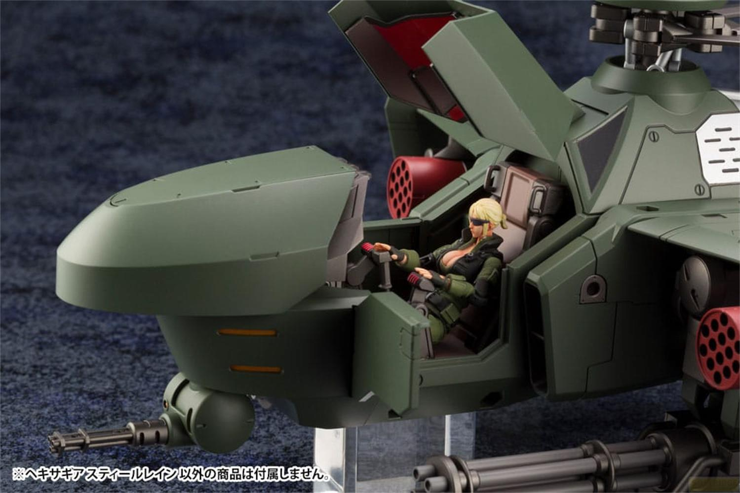 Eine weibliche Figur sitzt in einem grünen Hubschrauber-Cockpit mit Waffen.