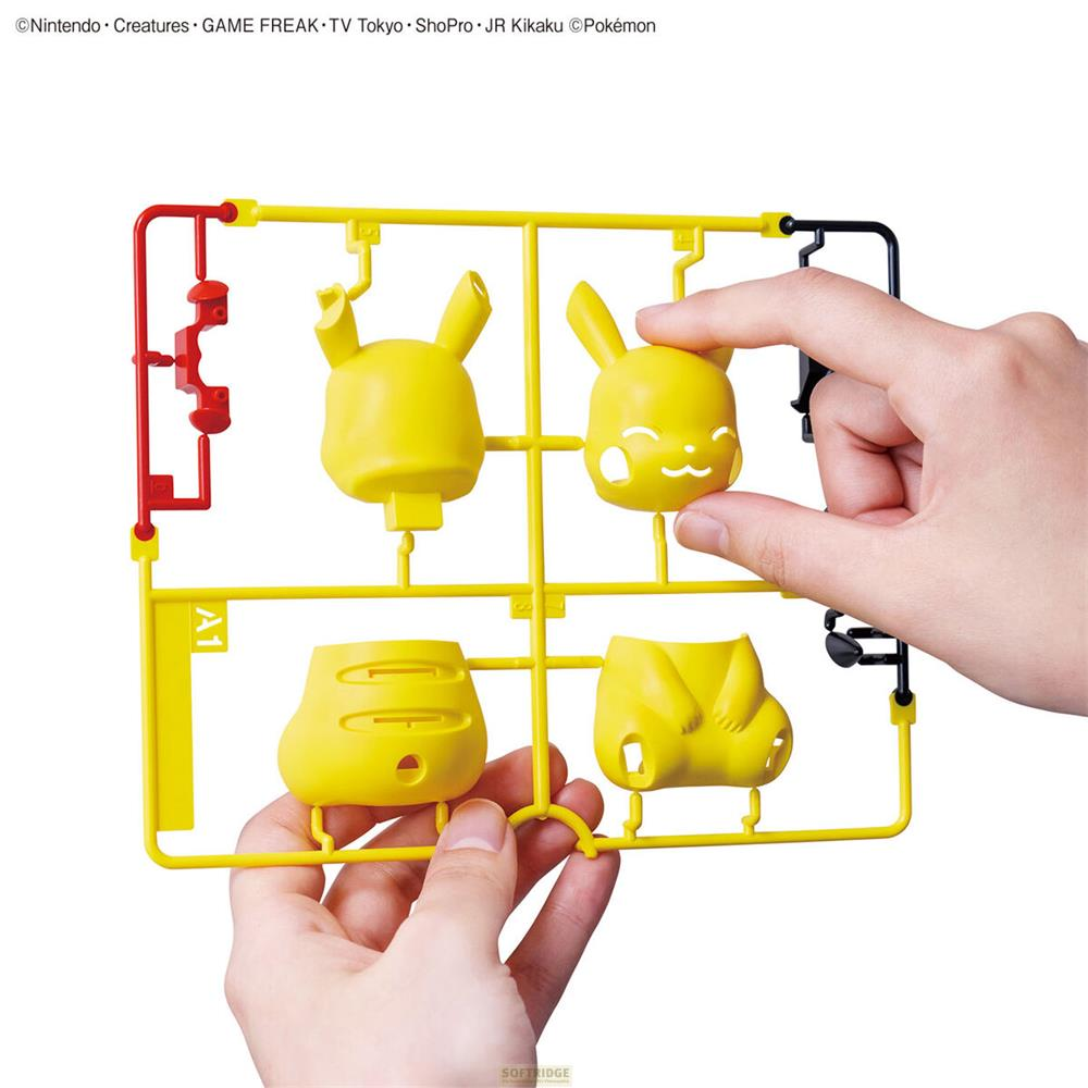 Des mains assemblent des pièces de tête de Pikachu sur une grappe de plastique jaune.