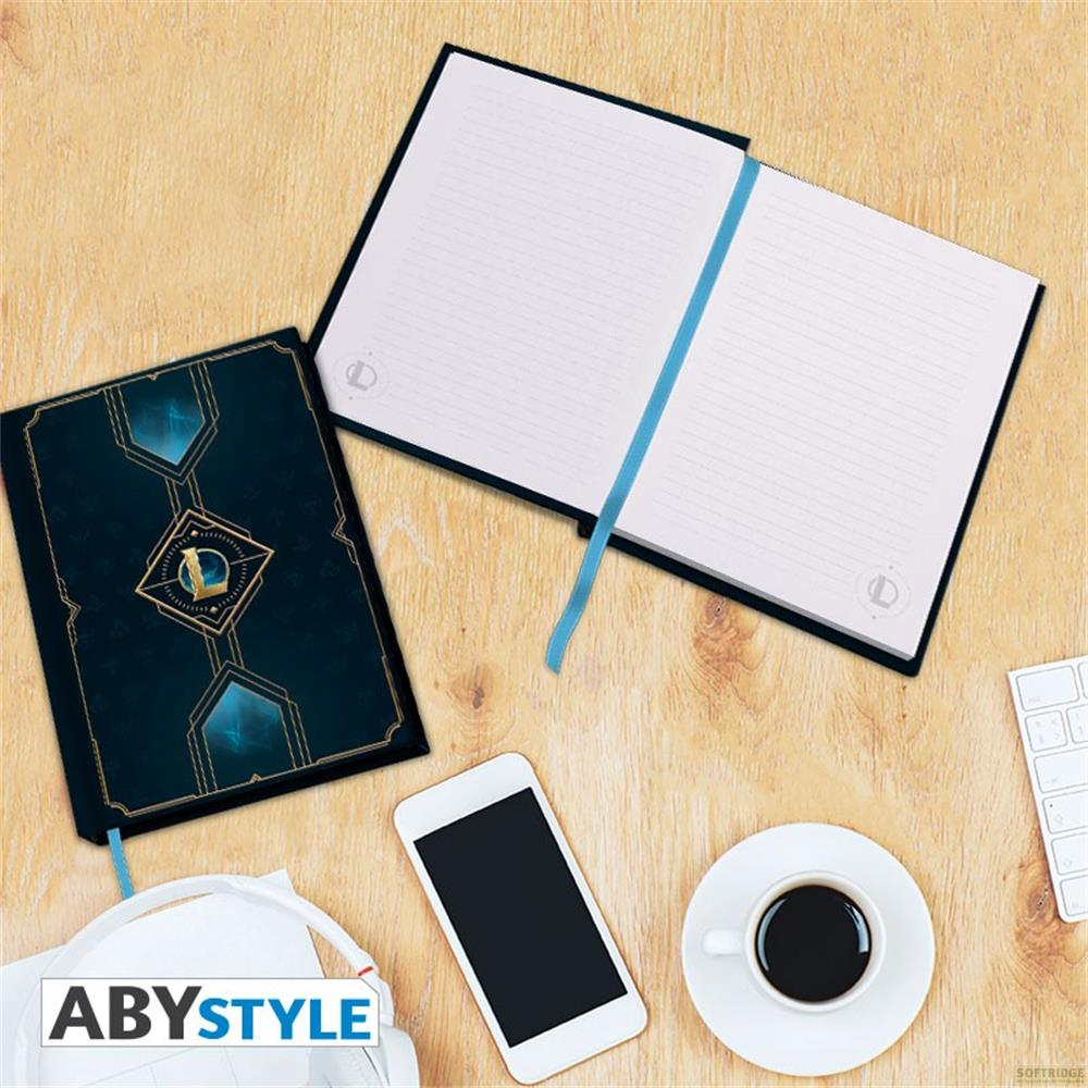 Ein Notizbuch mit dunklem Einband, ein offenes Notizbuch, ein Smartphone, Kopfhörer und eine Kaffeetasse.