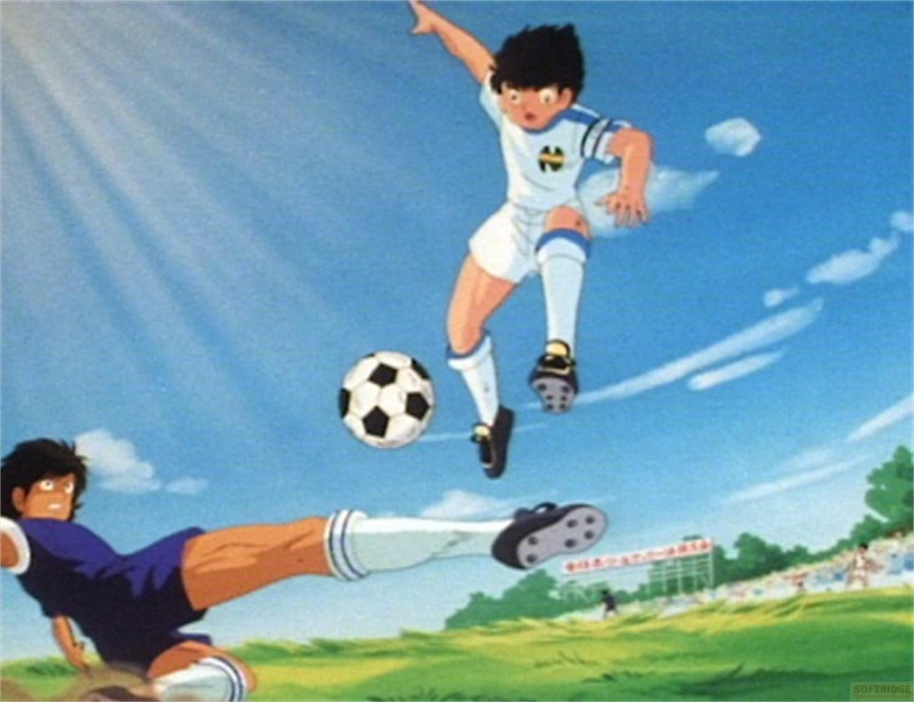 Deux footballeurs en l'air, l'un glissant, ballon en vol, ciel bleu.
