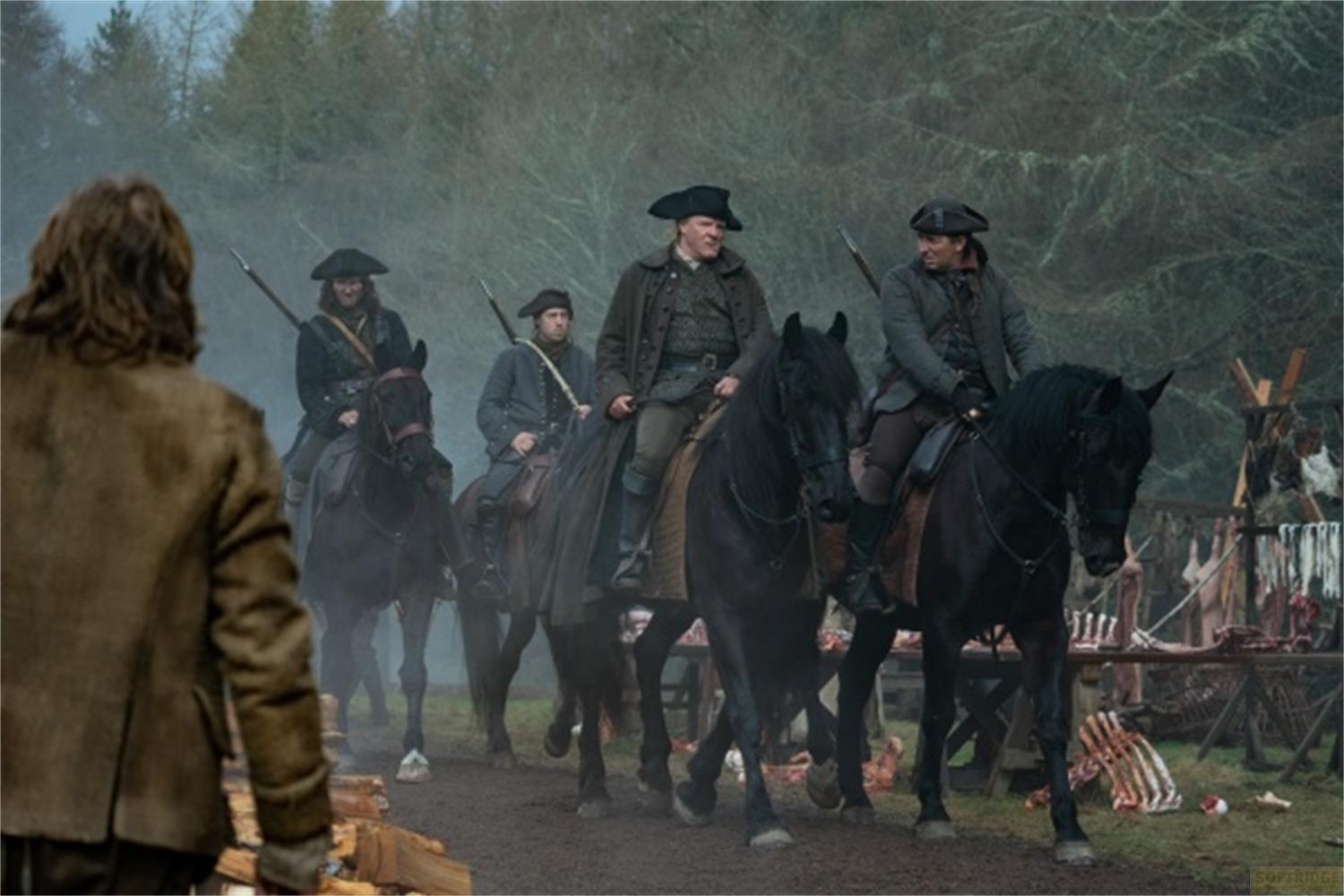 Männer in historischen Kostümen reiten auf schwarzen Pferden, im Hintergrund ein Wald und ein Marktstand mit Fleisch.