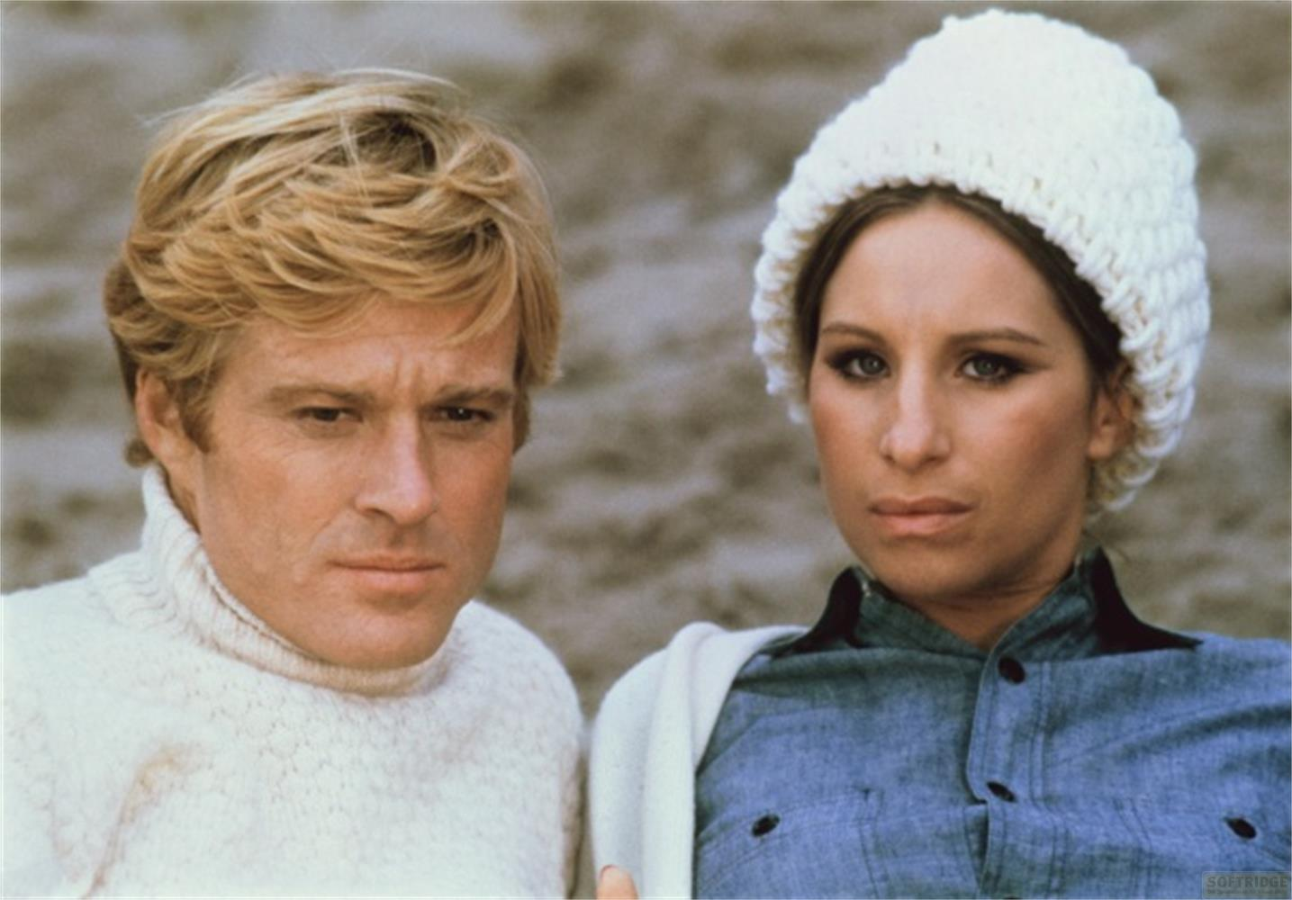 Homme blond en pull blanc, femme en bonnet blanc et chemise en jean.