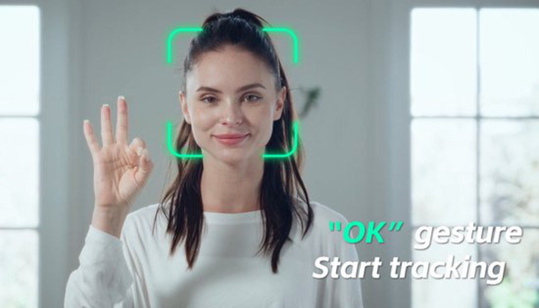 Vrouw maakt OK-gebaar. Groen kader om gezicht. Tekst 'OK' gebaar Start volgen.