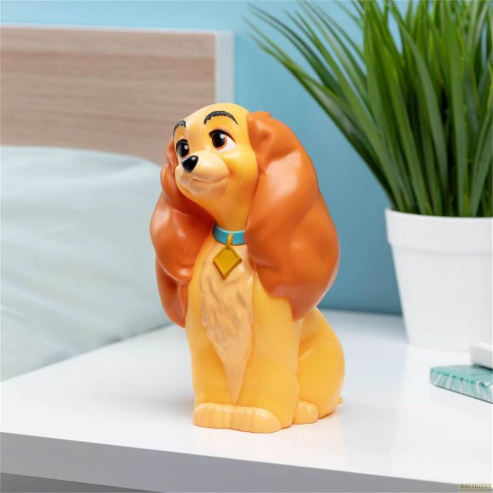 Eine gelbe Hundefigur mit braunen Ohren sitzt auf einem weißen Tisch.
