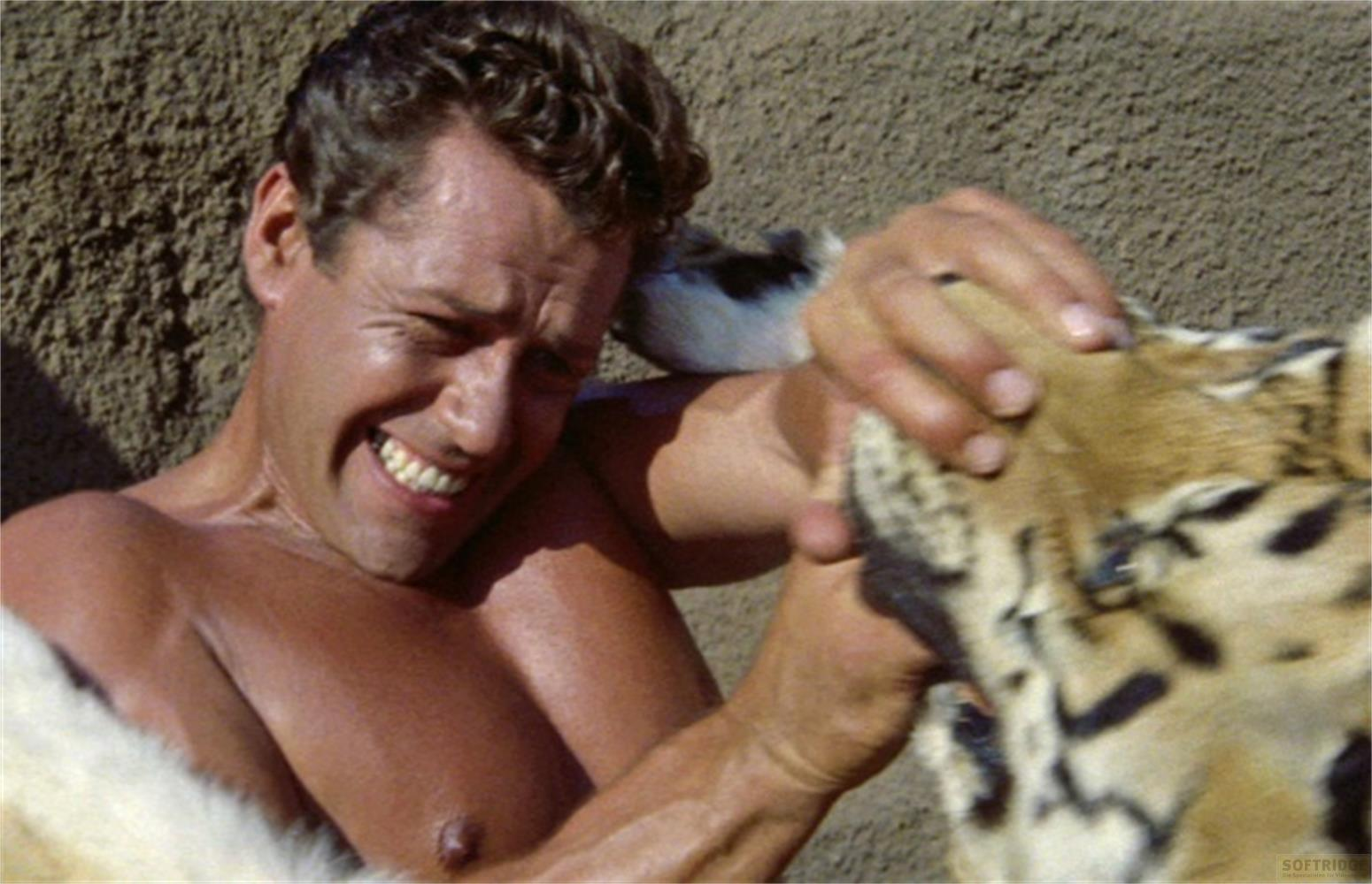 Un uomo ride mentre accarezza un animale.