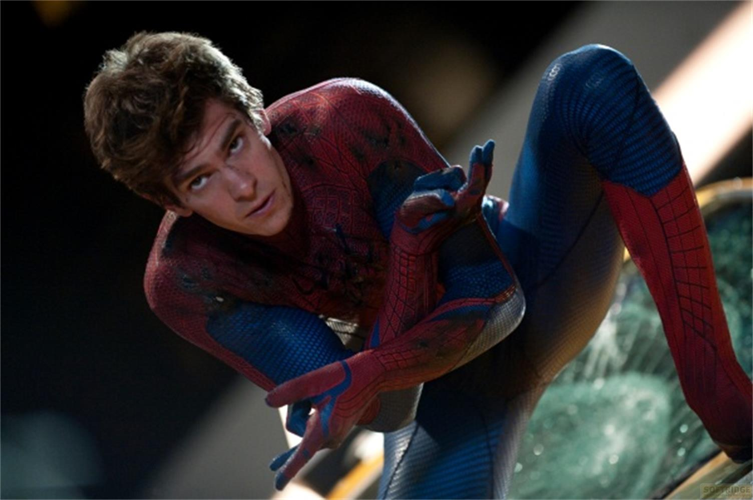 Un homme en costume de Spiderman rouge et bleu regarde vers le bas.