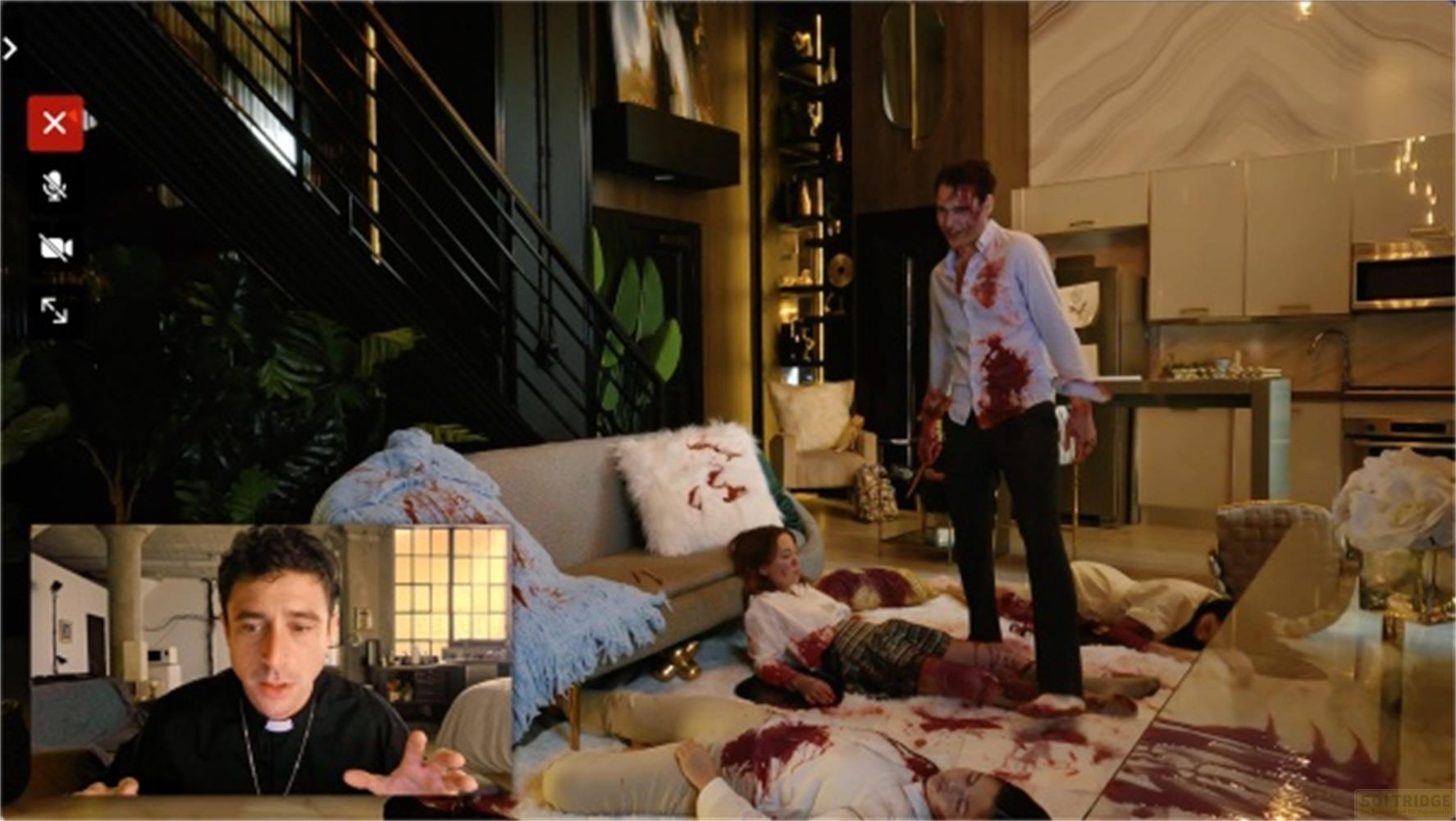 Uomo in abiti macchiati di sangue, sopra corpi in un lussuoso salotto.