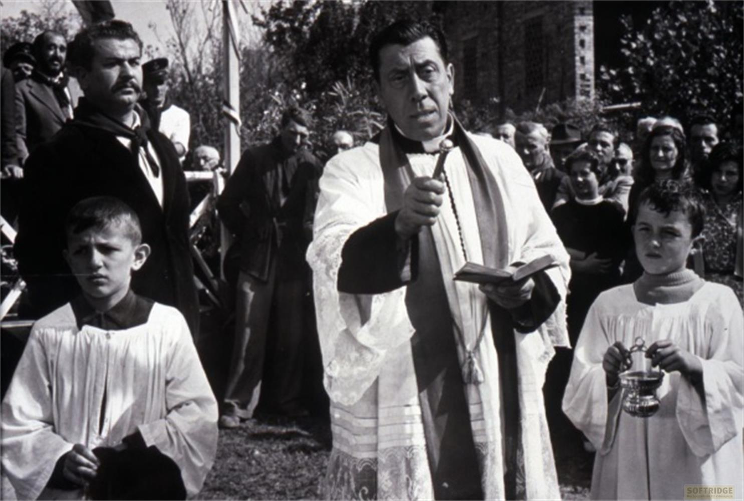 Un sacerdote tiene un libro e un crocifisso davanti a una folla.