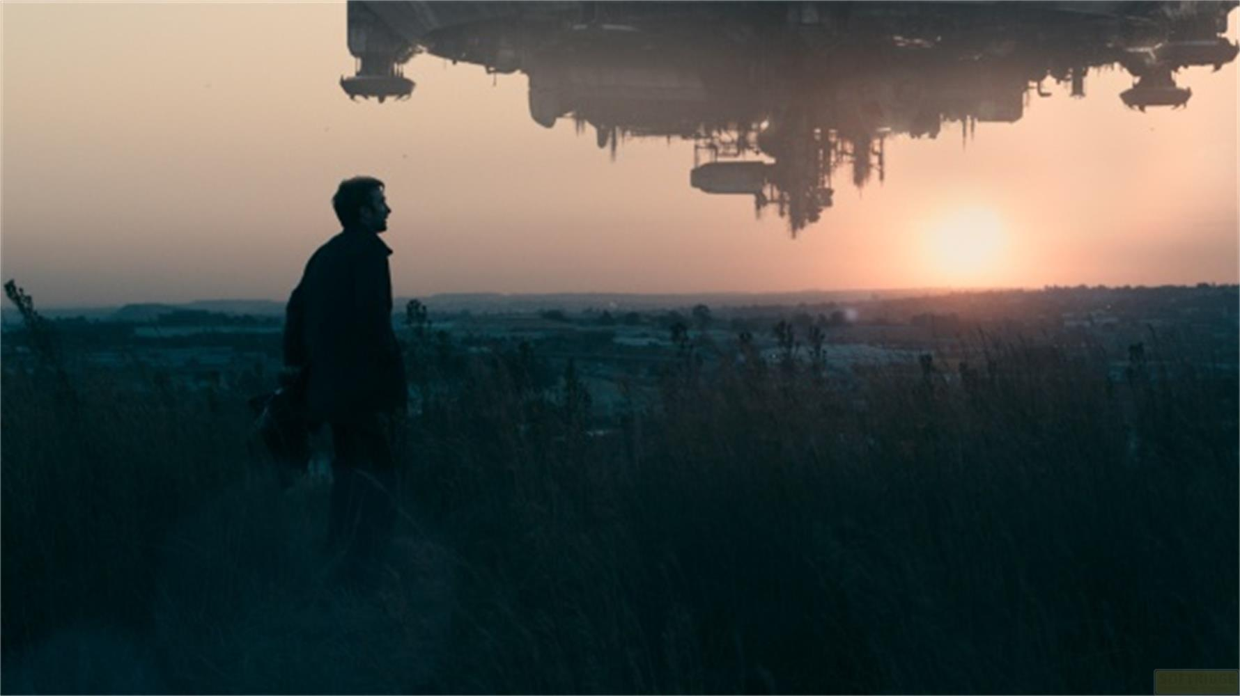 Un uomo in un campo al tramonto, un'astronave fluttua sopra di lui.