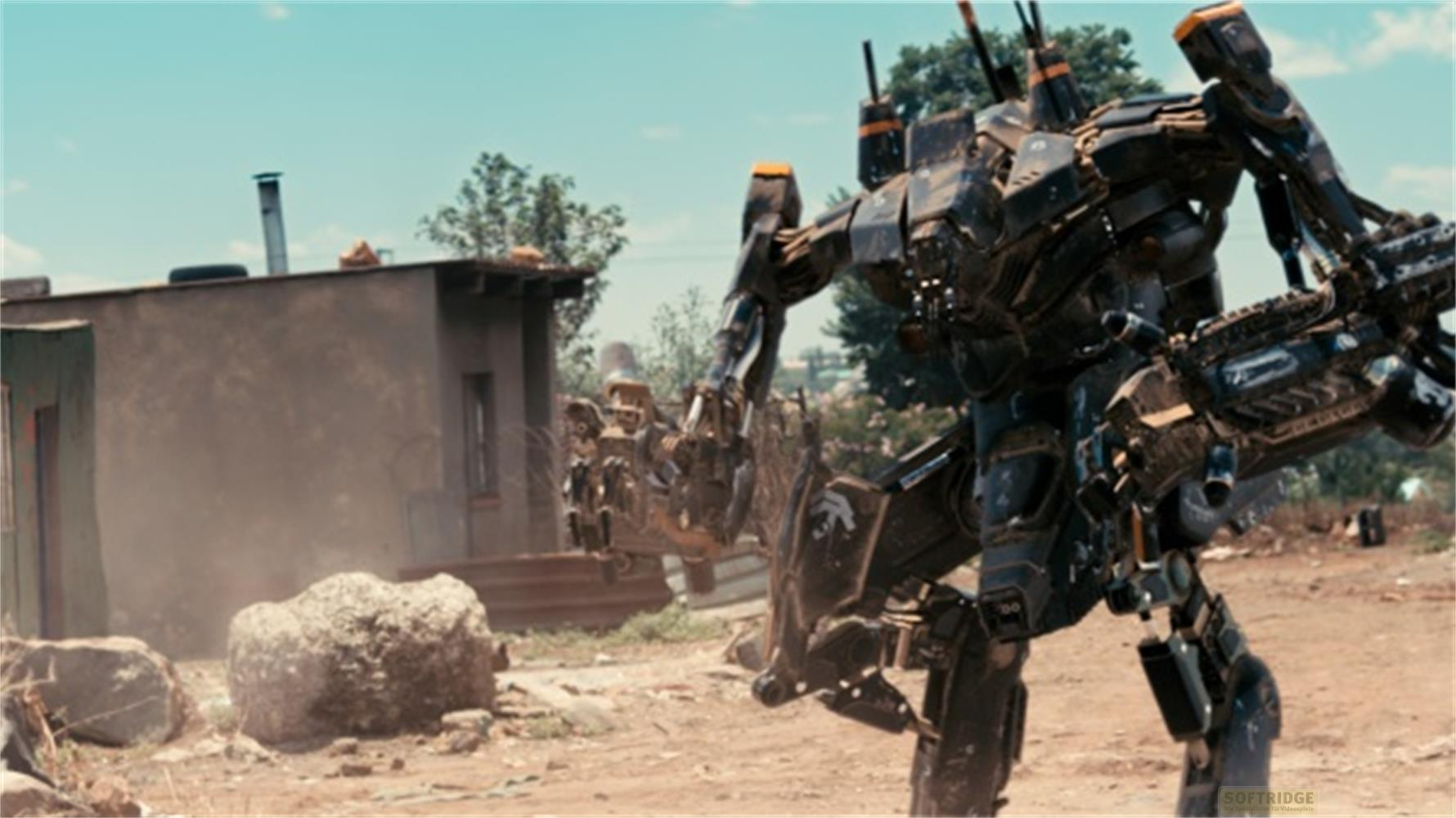 Un grande mech scuro si trova davanti a una piccola casa. La polvere turbina.