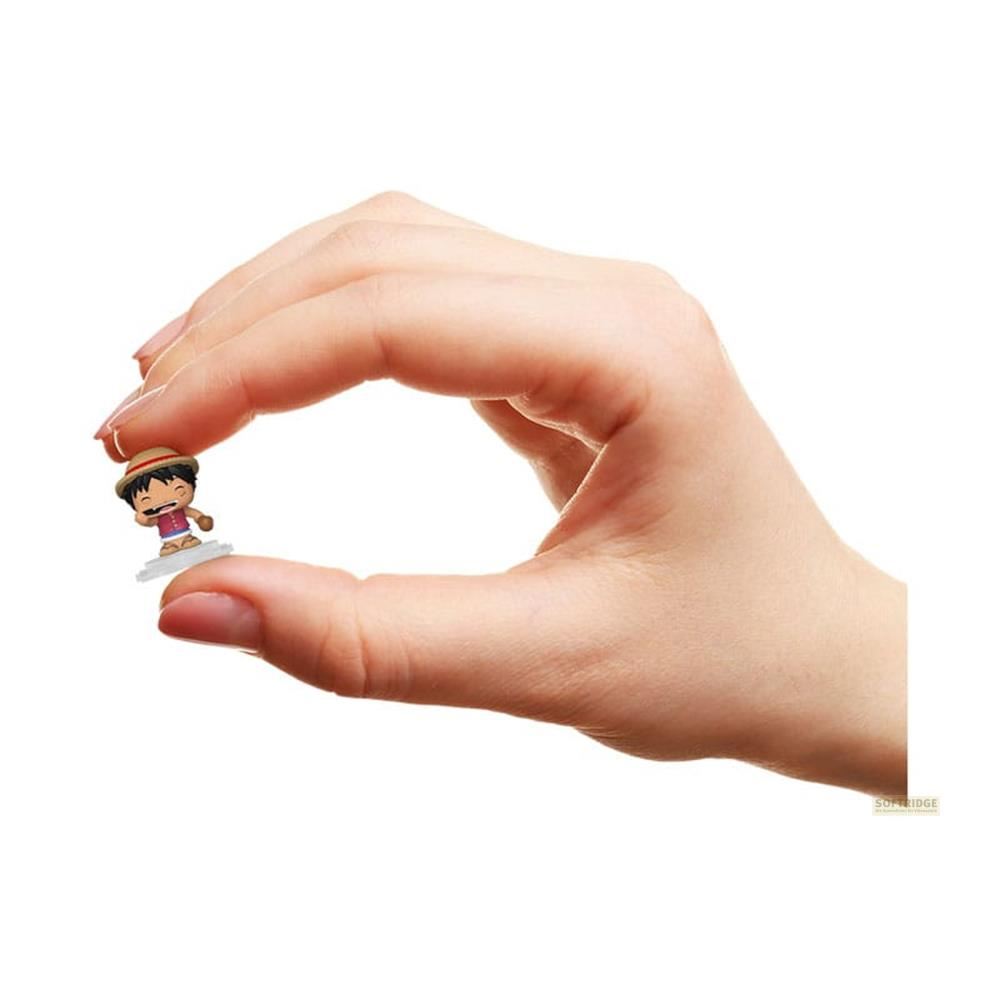 Eine Hand hält eine winzige Figur mit Strohhut und rotem Hemd.