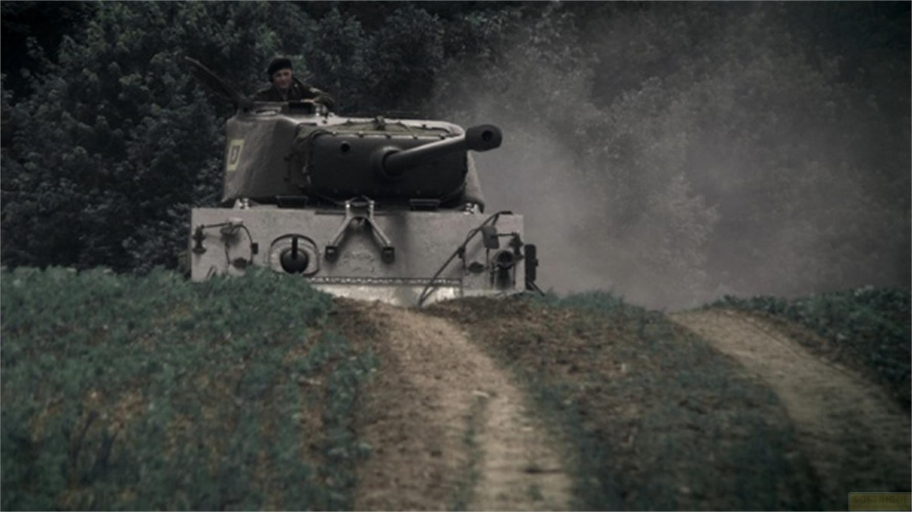 Ein Soldat in einem Panzer fährt auf einem Feldweg, umgeben von Bäumen.