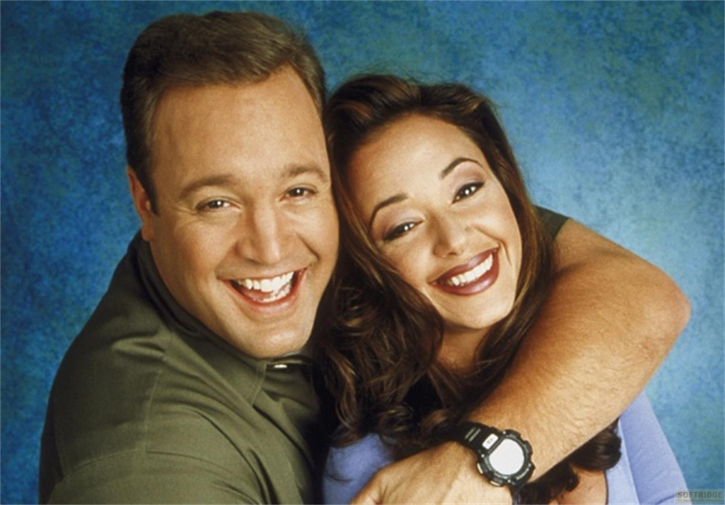 Un homme et une femme sourient chaleureusement sur fond bleu.